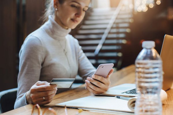 Mulher usando smartphone em ponto de venda virtual