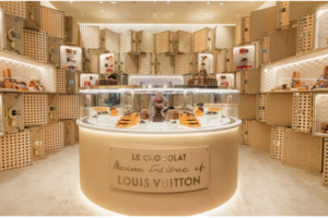Espaço experiencial de fan zone no varejo da Louis Vuitton com exposição de produtos premium, design imersivo e ambiente de varejo de luxo focado na experiência do consumidor.