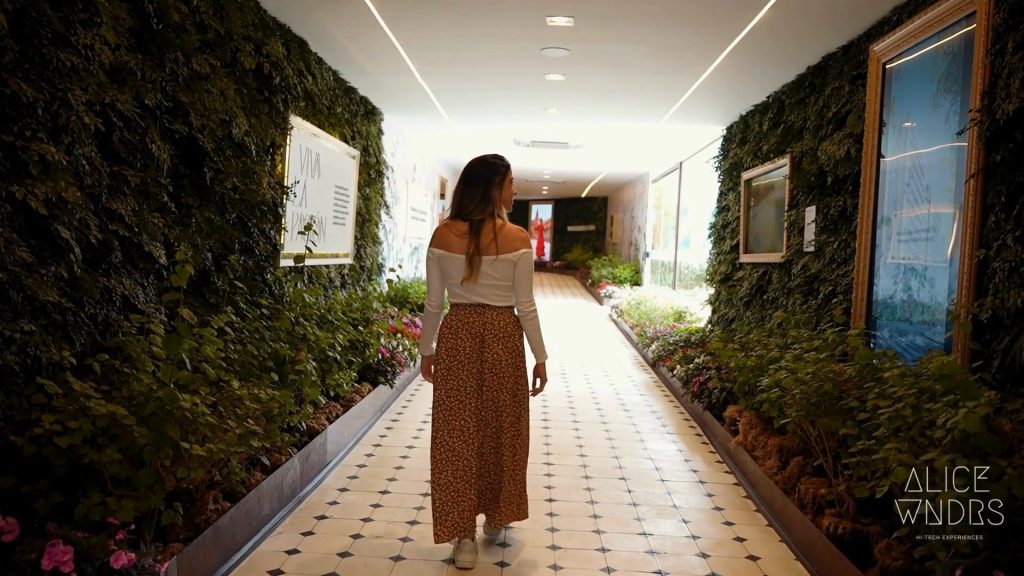 Pessoa caminhando por um ambiente imersivo e biofílico, representando um case de varejo experiencial focado em pertencimento, conexão emocional e jornada do consumidor.