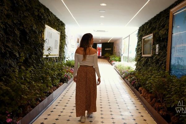 Pessoa caminhando por um ambiente imersivo e biofílico, representando um case de varejo experiencial focado em pertencimento, conexão emocional e jornada do consumidor.