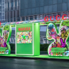Vitrine tecnológica da Gucci com instalação interativa e iluminação verde em espaço urbano