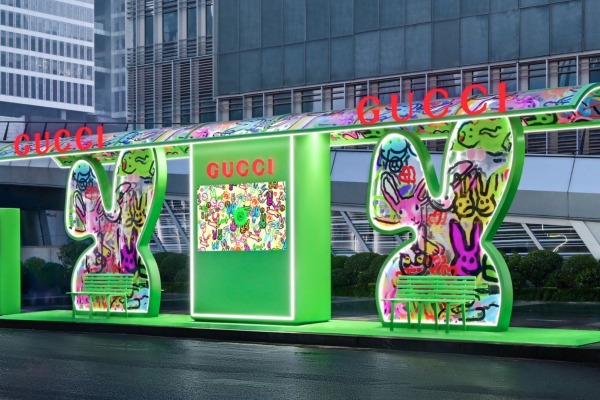 Vitrine tecnológica da Gucci com instalação interativa e iluminação verde em espaço urbano